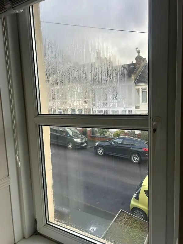 Before: a window with a misted sealed unit, fogged with droplets between the panes
